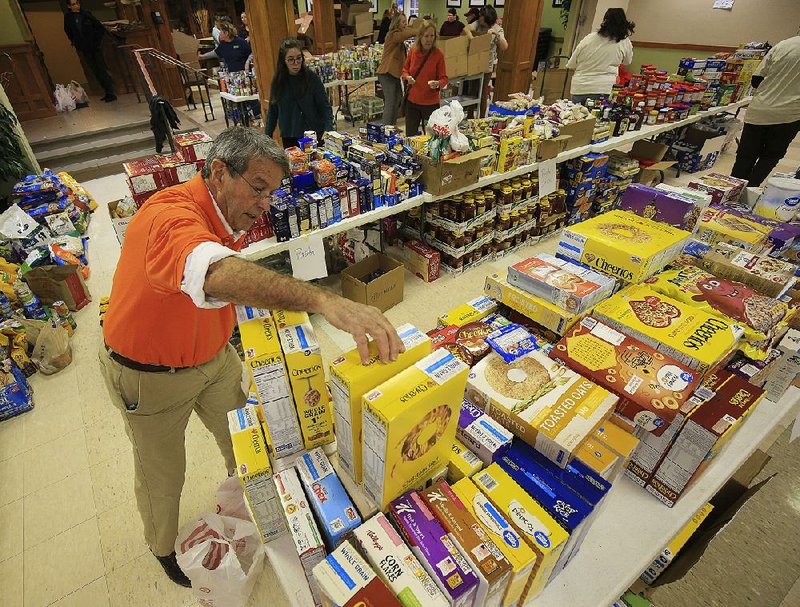 Gordon Garlington works with other volunteers Wednesday sorting food donated for the Little Rock Cares federal workers donation drive at First United Methodist Church in Little Rock. The items collected are to be given out Friday to federal employees at Bill and Hillary Clinton National Airport/Adams Field. 