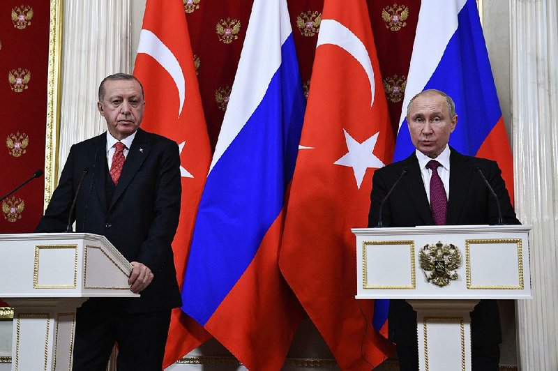 Russian President Vladimir Putin (right) speaks Wednesday during a news conference with Turkish President Recep Tayyip Erdogan in Moscow. Both leaders see U.S. troops in Syria as an obstacle to their plans for that country. 