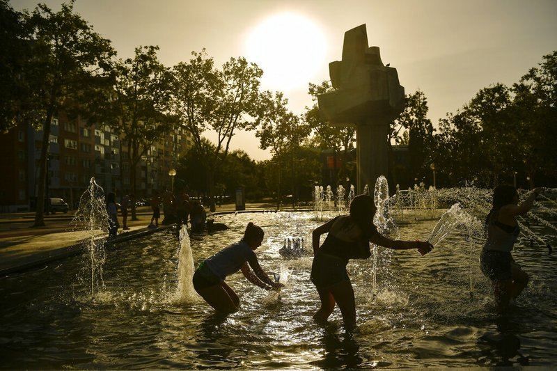 In this Saturday, Aug. 4, 2018 file photo, people cool off in a fountain during a hot summer day in the Basque city of Vitoria, northern Spain. In 2018, 29 countries and Antarctica had record hot years, says Berkeley Earth climate scientist Zeke Hausfather. (AP Photo/Alvaro Barrientos)