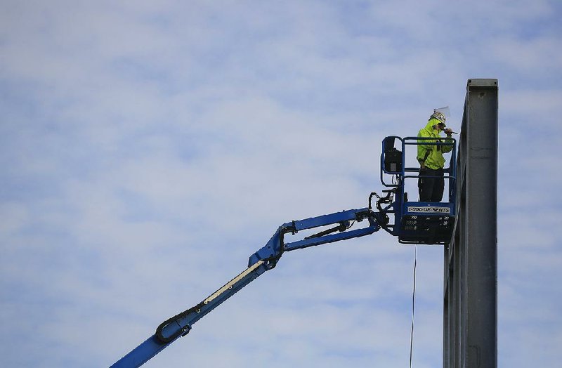 In this file photo a construction worker stands on a lift Thursday as he works on the steel being put up as part of the Argenta Plaza project in downtown North Little Rock. 