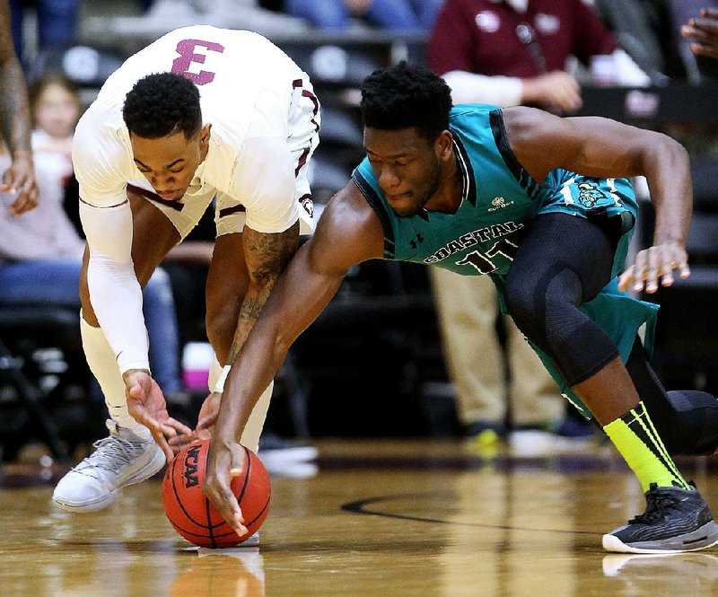 In this file photo UALR’s Rayjon Tucker (left) and Coastal Carolina’s Amidou Bamba fight for a loose ball at the Jack Stephens Center in Little Rock. 