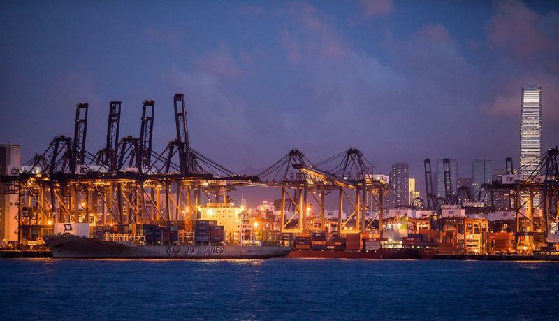 Gantry cranes stand at the Kwai Tsing container terminal operated by Hongkong International Terminals Ltd. as the International Commerce Center stands illuminated in the background in Hong Kong. 
