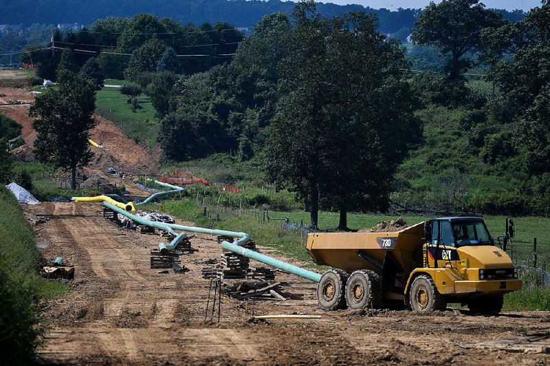 Sections of pipe and a dump truck sit at a construction site for a natural gas liquids pipeline project near Morgantown, Pa., in 2017. 