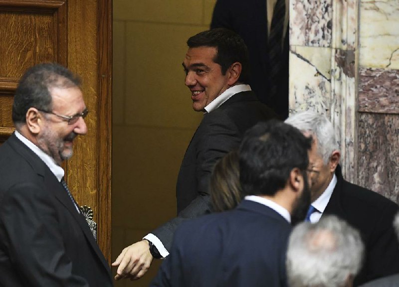 Greek Prime Minister Alexis Tsipras (center) jokes with aides Friday after lawmakers ratified an agreement resolving Greece’s objections to Macedonia joining NATO. 