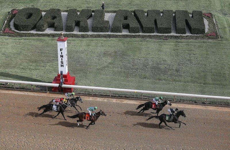 Horses cross the finish line in the second race at Oaklawn Park in Hot Springs on Friday, the opening day of the track’s live racing season. See more photos at arkansasonline.com/galleries.