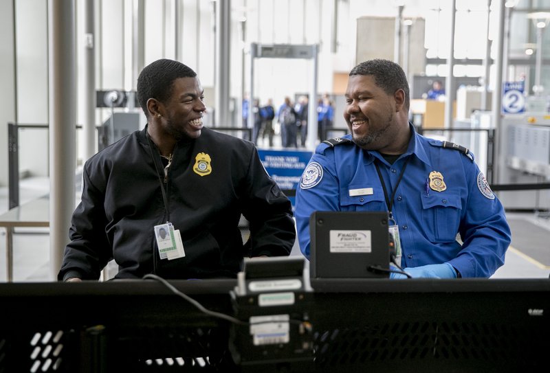 Transportation Security Administration officers smile at a security checkpoint at Austin-Bergstrom International Airport in Austin, Texas, on Friday, Jan. 25, 2019, moments President Donald Trump announced a deal with Congress to reopen the federal government. (Jay Janner/Austin American-Statesman via AP)