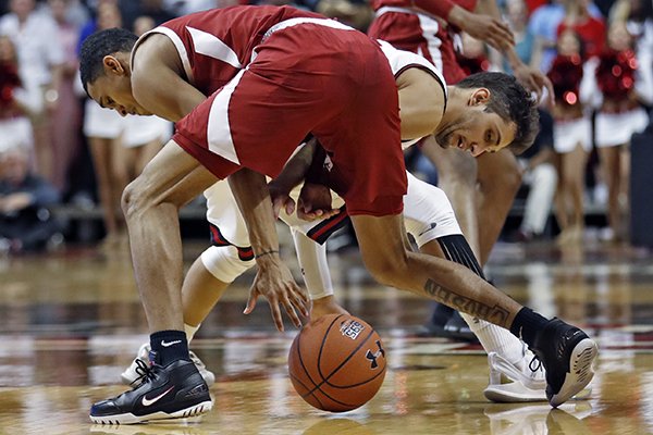 Texas Tech's Davide Moretti tries to steal the ball away from Arkansas' Jalen Harris, back to camera, during the second half of an NCAA college basketball game Saturday, Jan. 26, 2019, in Lubbock, Texas. (AP Photo/Brad Tollefson)
