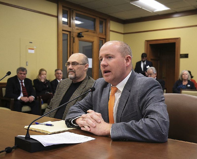 Rep. Jeff Wardlaw (right), R-Warren, and Michale Grappe with the Arkansas Department of Environmental Quality speak Tuesday in a committee meeting at the state Capitol about HB1007 that deals with permits issued by ADEQ for disposal of animal waste by farmers. 