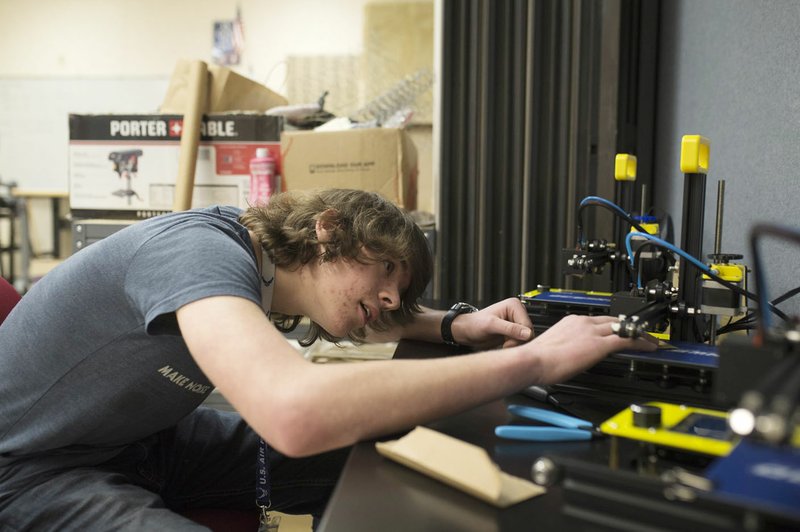 NWA Democrat-Gazette/CHARLIE KAIJO Sophomore Johnathan Hartman, 16, levels the platform of a 3D printer Jan. 18 at Bentonville High School. The school recently opened Innovation Hub, where kids can tinker, create and design.