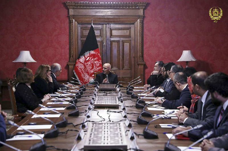 Afghan President Ashraf Ghani (center) speaks to U.S. peace envoy Zalmay Khalilzad (third left) in Kabul, Afghanistan, on Monday in this photo released by the Afghan presidential palace. 