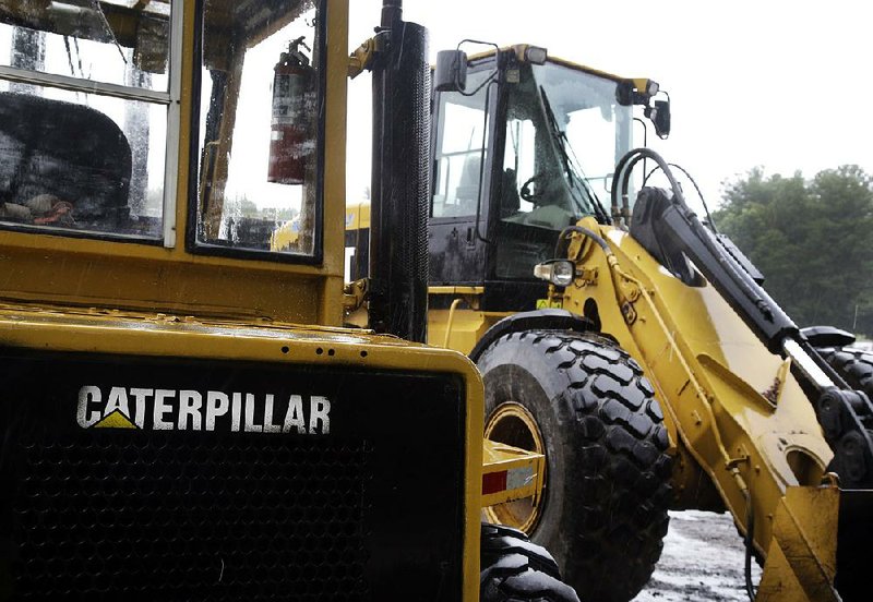 Caterpillar loaders sit parked in Middleton, Mass. Caterpillar missed profit expectations for the fourth quarter. 