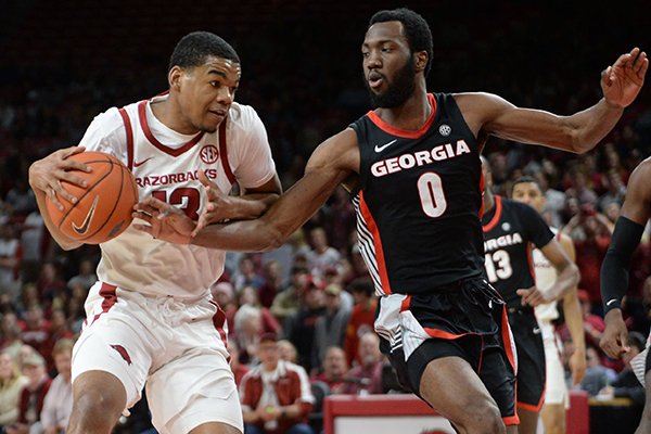Arkansas guard Mason Jones (left) drives to the basket as Georgia guard Williams Jackson II (0) defends Tuesday, Jan. 29, 2019, during the first half of play in Bud Walton Arena.