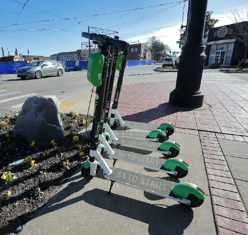 Lime scooters sit lined up at Sixth and Main streets in North Little Rock on Tuesday afternoon. 