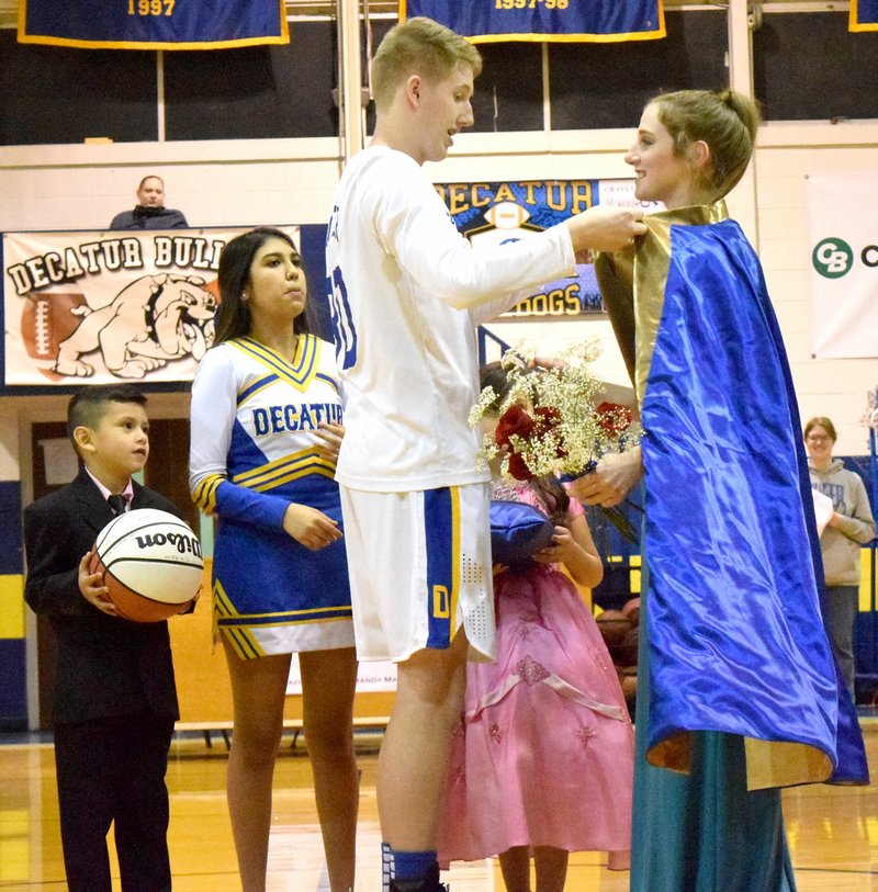 Westside Eagle Observer/MIKE ECKELS King Ryan Ross (center) ties a ceremonial sash round queen Sammie Skaggs' neck during the 2019 Colors Day coronation at Peterson Gym in Decatur Jan. 25. Participating in the ceremony are Jan Hernandez (left), Anna Ruiz, Ross, Sophie Garica (center right) and Skaggs.