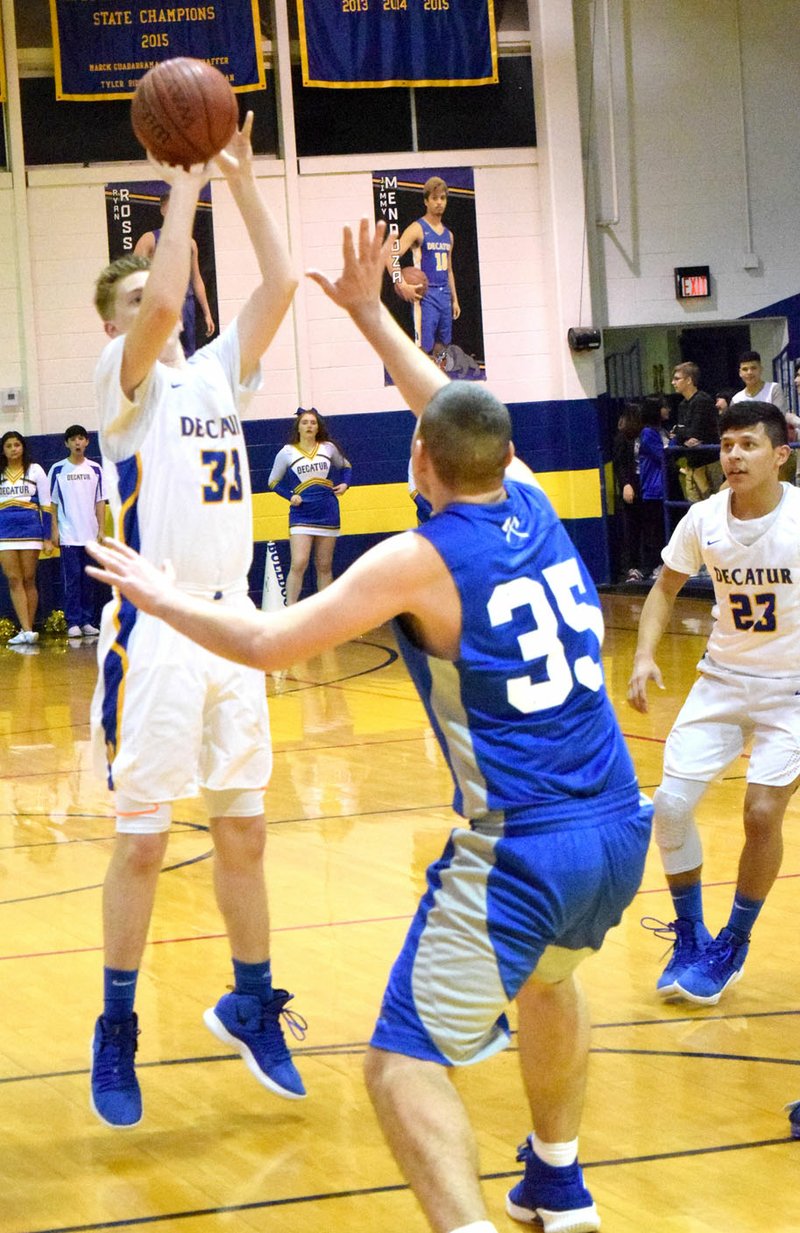 Westside Eagle Observer/MIKE ECKELS Conner Sutton (Decatur 33) puts up a jumper over Issac Jones (Cotter 35) during the fourth quarter of the Decatur-Cotter conference matchup Jan. 25 in Decatur. Sutton hit the shot for two of his seven points for the night.