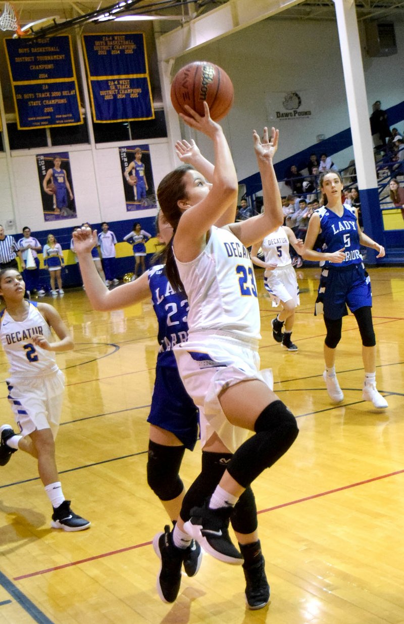 Westside Eagle Observer/MIKE ECKELS Abby Tilley (Decatur 23) flies past Paige Clawson (Lady Warriors 23) on her way to the basket for a layup during the Jan. 25 Decatur-Cotter conference matchup in Decatur. Tilley hit the layup for two of her 11 points for the night.