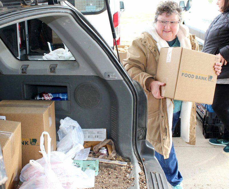 COURTESY OF THE NORTHWEST ARKANSAS FOOD BANK Gravette volunteer Frankie Stephens loads a box of groceries, Tuesday, Jan. 22, at the Billy V. Hall complex, 1870 Limekiln Road, as the Northwest Arkansas Food Bank made its first mobile pantry visit. The mobile pantry will visit Gravette at 10 a.m. on the fourth Tuesday of each month. The mobile pantry served more than 60 households in the Gravette area during its visit. Those receiving assistance from the mobile pantry received a box of non-perishable food, a bag of protein, a bag of vegetables and bread.