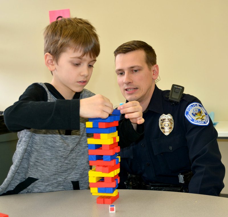 Janelle Jessen/Herald-Leader Zachery Calcott, a student at Southside Elementary School, plays a game of Jenga with Josh Fritz, a school resource officer with the Siloam Springs Police Department. The pair are part of the Bigs with Badges program being piloted at Big Sisters Big Brothers of Siloam Springs.