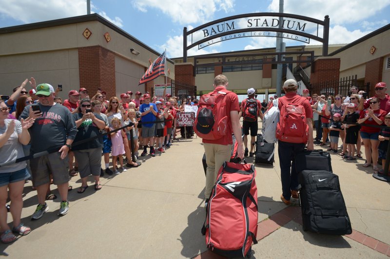 FILE — Arkansas players walk into the stadium with equipment and luggage on Friday, June 29, 2018, as fans line the sidewalk at Baum Stadium in Fayetteville to welcome back the Razorback baseball team from its trip to the College World Series.