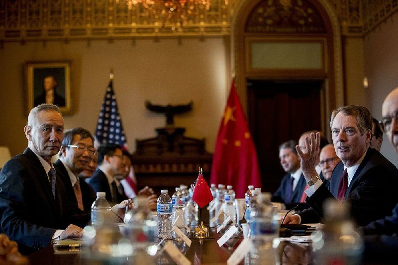 Chinese Vice Premier Liu He (left) and U.S. Trade Representative Robert Lighthizer (right) sit surrounded by officials from both countries Wednesday as they begin trade talks at the White House. 