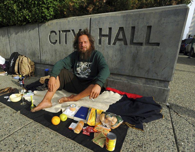 In this July 1, 2011, file photo, John Martin camps out in front of City Hall in downtown Anchorage, Alaska, to protest the city's practice of clearing homeless camps. Martin has been detained since August 2018 in Russia after his dinghy washed ashore there in his attempt to sail from Alaska to China. He expects to be back in Alaska on Sunday, Feb. 3, 2019. (Bob Hallinen/Anchorage Daily News via AP, File)
