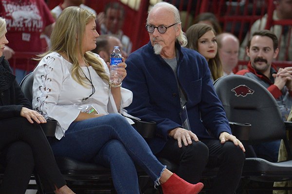 Johnny Mike Walker (right) sits with Mandy Macke, executive director of the Willard & Pat Walker Charitable Foundation, during a game between Arkansas and Texas State on Saturday, Dec. 22, 2018, in Fayetteville.