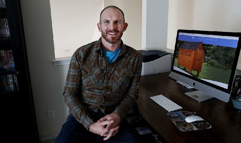 Simon Trask poses for a photo sitting at his home office desk Tuesday in Denton, Texas. 