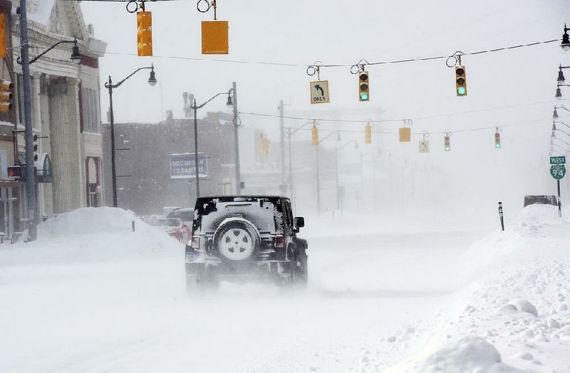 A Jeep drives in near whiteout conditions Thursday in downtown Benton Harbor, Mich. 