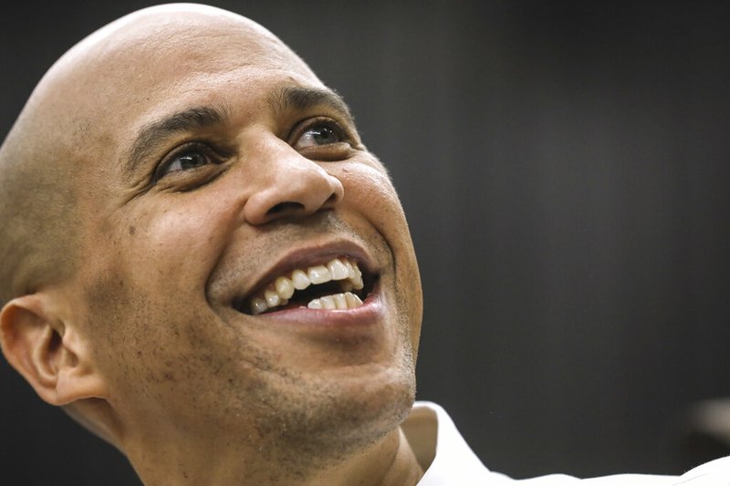 In this Oct. 28, 2018, file photo, Sen. Cory Booker, D-N.J., looks up as he takes a selfie with an attendee after speaking attends at a get out the vote event hosted by the NH Young Democrats at the University of New Hampshire in Durham, N.H. (AP Photo/ Cheryl Senter, File)