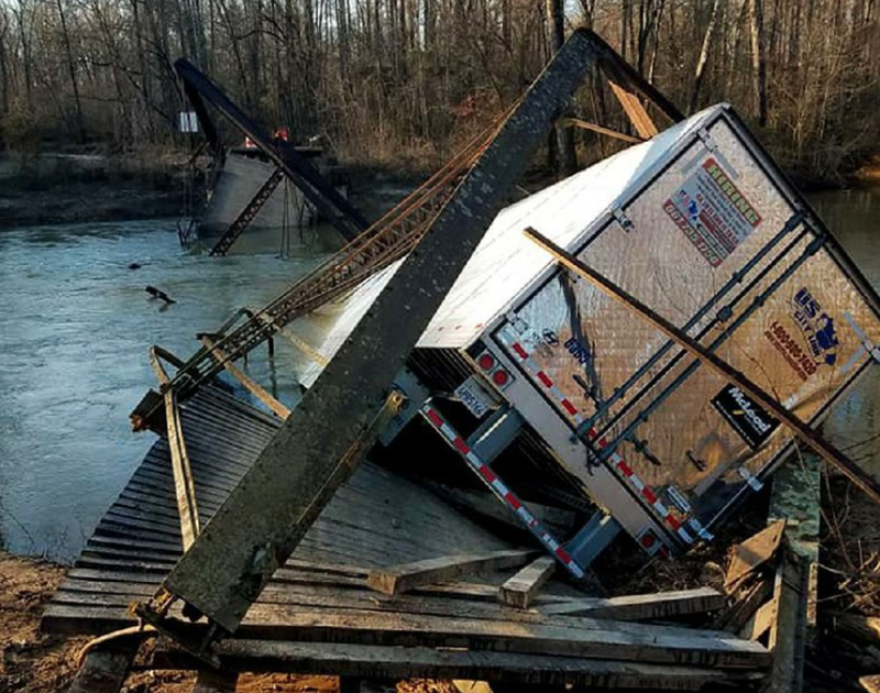 An 18-wheeler rests on parts of the collapsed Dale Bend bridge over the Petit Jean River near Ola on Thursday in Yell County.