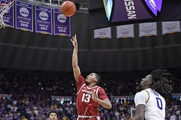 As LSU guard Marlon Taylor (14) and LSU forward Naz Reid (0) watch, Arkansas guard Mason Jones (13) puts the ball up for the go-ahead basket with seconds remaining in an NCAA college basketball game Saturday, Feb. 2, 2019, in Baton Rouge, La. Arkansas won 90-89. (AP Photo/Bill Feig)


