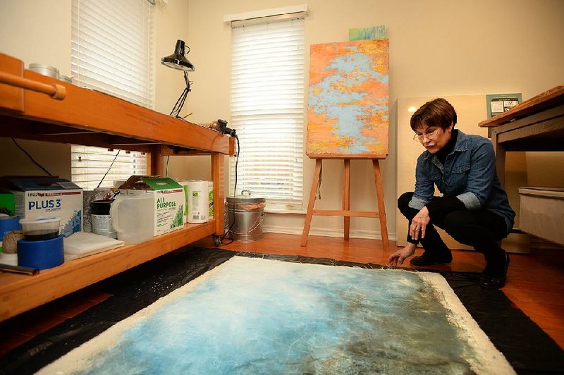 Artist Denise Sagan describes her process in creating multimedia artwork Thursday in her home studio in Fayetteville. 