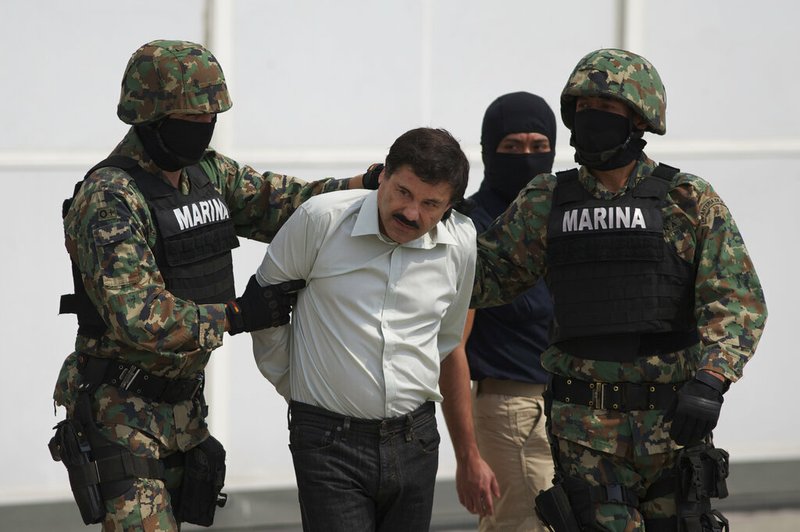 In this Saturday, Feb. 22, 2014 file photo, Joaquin "El Chapo" Guzman, center, is escorted to a helicopter in handcuffs by Mexican navy marines at a hanger in Mexico City, after he was captured overnight in the beach resort town of Mazatlan. The New York trial of Guzman is drawing to a close, but the question of controlling the corruption that allowed the Sinaloa cartel to flourish in Mexico will live on even after jurors reach a verdict. DEA agent Victor Vazquez told jurors he would only work with the Mexican marines when trying to capture Guzman and other leaders of the Sinaloa cartel, because that wing of the armed forced were viewed as less susceptible to corruption. (AP Photo/Eduardo Verdugo, File)