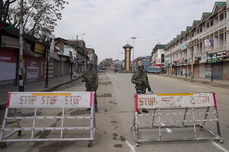 Indian paramilitary soldiers stand guard near a temporary check point during a strike in Srinagar, Indian controlled Kashmir, Sunday, Feb. 3, 2019. India's prime minster is in disputed Kashmir for a daylong visit Sunday to review development work as separatists fighting Indian rule called for a shutdown in the Himalayan region. (AP Photo/Dar Yasin)