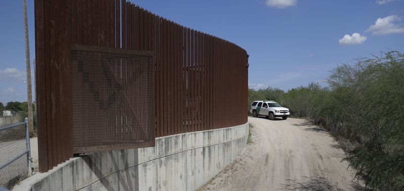 FILE - In this Aug. 11, 2017, file photo, a U.S. Customs and Border Patrol vehicle passes along a section of border levee wall in Hidalgo, Texas. The U.S. government is preparing to begin construction of more border walls and fencing in South Texas' Rio Grande Valley, likely on federally-owned land set aside as wildlife refuge property. Heavy construction equipment is supposed to arrive starting Monday. A photo posted by the nonprofit National Butterfly Center shows an excavator parked on its property. (AP Photo/Eric Gay, File)