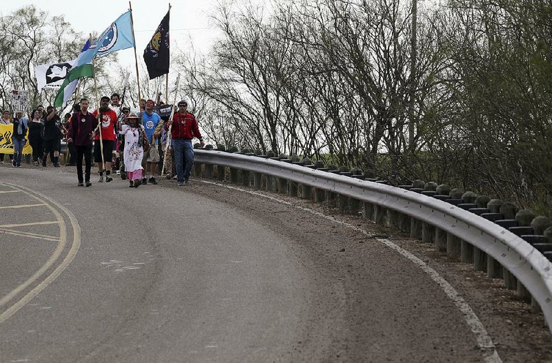 Members of the Carrizo/Comecrudo Tribe along with other opponents of wall construction convene near the river and make their way about 3 miles down to the National Butterfly Center to protest Monday in Mission, Texas. 