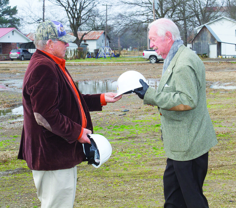 Woodruff County Judge Charles Dallas, left, hands a hard hat to former county judge and former Augusta Mayor Burl Simmons prior to a ceremonial groundbreaking for the new Woodruff County Jail on Jan. 18.