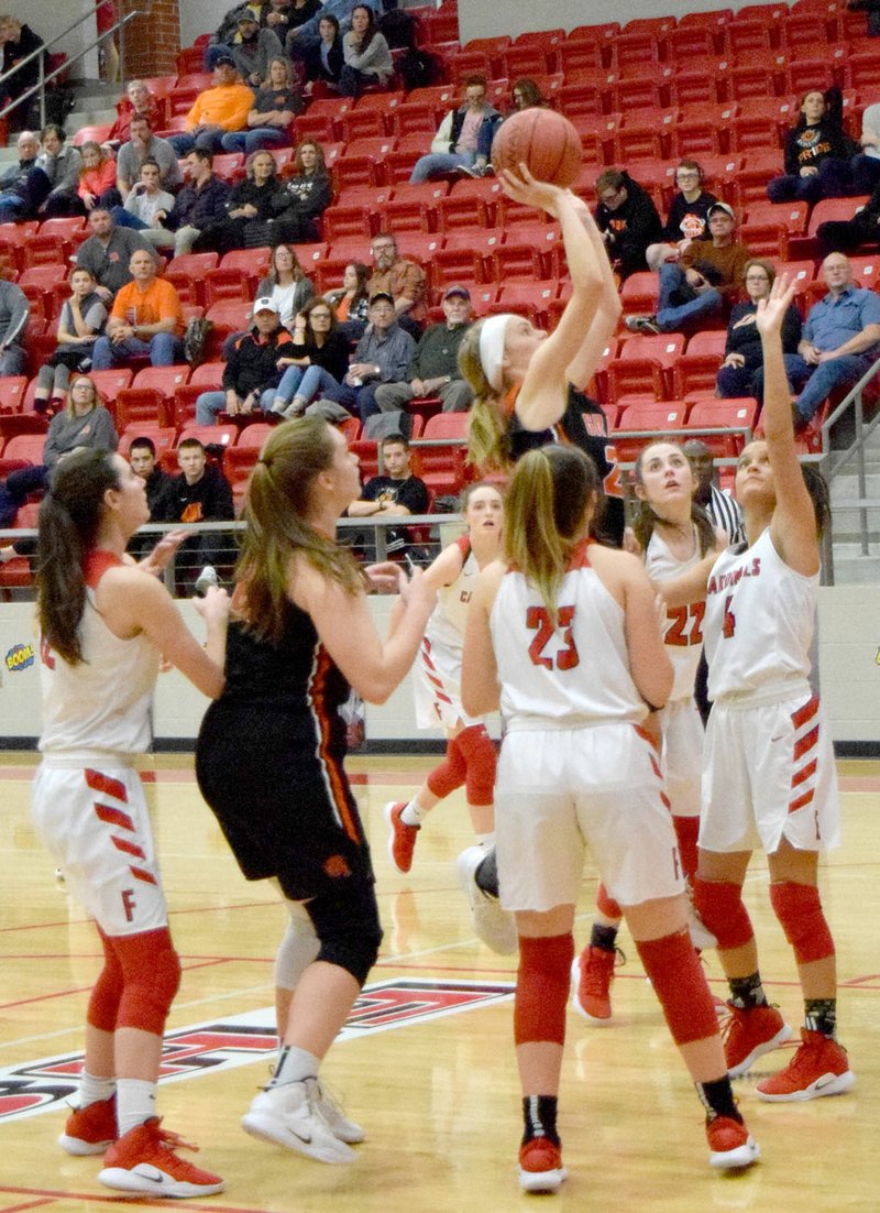 Westside Eagle Observer/MIKE ECKELS Lady Lion Jessica Bookout (wearing headband) manages a shot in spite of the flock of Lady Cardinals trying to put up a defensive line during the Farmington-Gravette girls' basketball contest at Cardinal Arena in Farmington Feb. 1.