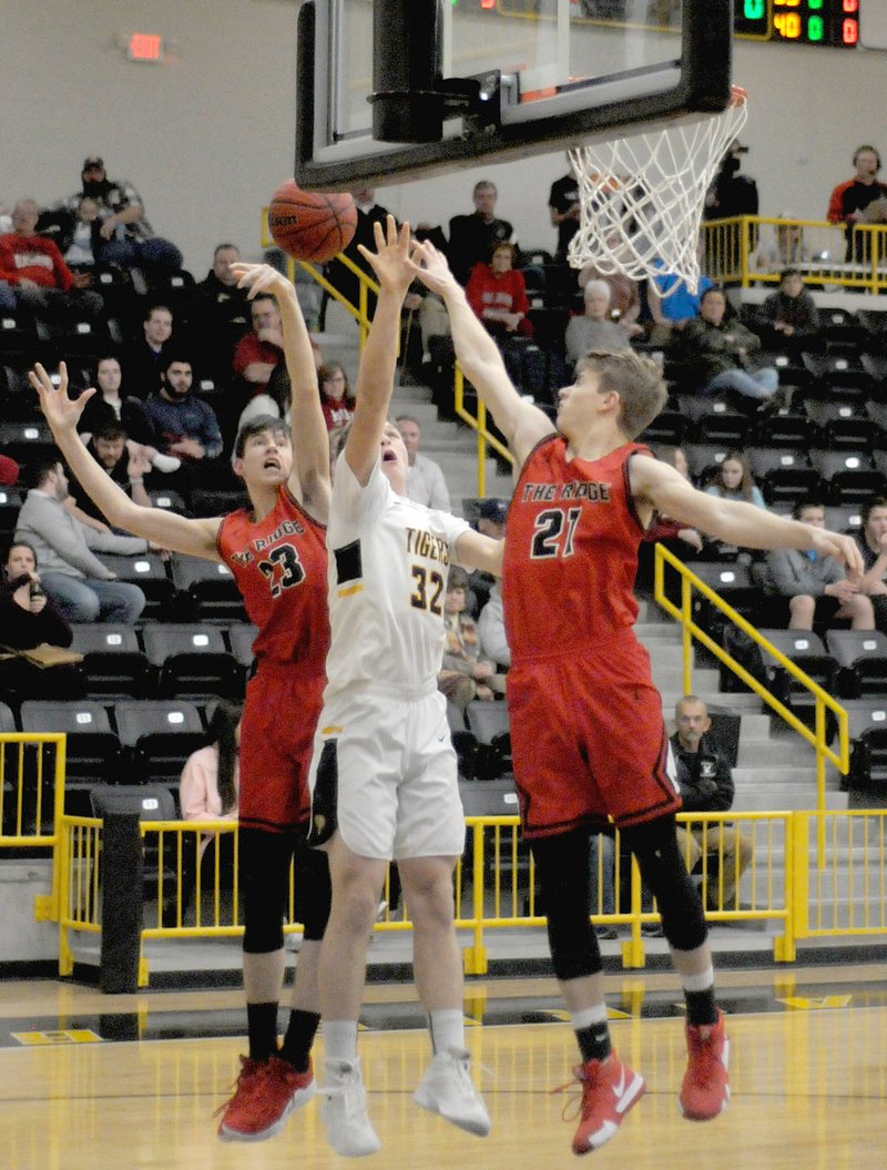 Mark Humphrey Special to the Times/Pea Ridge junior Wes Wales and senior Nick Coble combine to block a shot by Prairie Grove's James Millwood in the first half of Friday's 48-37 win by the Blackhawks at Tiger Gymnasium.