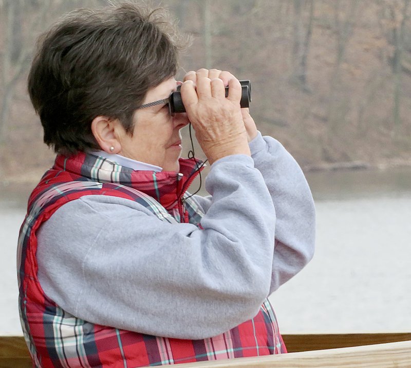 Westside Eagle Observer/RANDY MOLL Mary Riorden of Bella Vista watches for birds from a pavilion along the Eagle Watch Nature Trail on Saturday. Riorden was one of more than 40 bird watchers who came out to Eagle Watch as a part of a Northwest Arkansas Audubon Society field trip on Saturday morning.