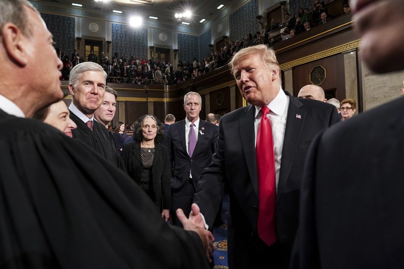 President Donald Trump talks to Supreme Court Chief Justice John Roberts while leaving the House chamber after giving his State of the Union address to a joint session of Congress on Tuesday at the Capitol in Washington. (Doug Mills/The New York Times via AP, Pool)

