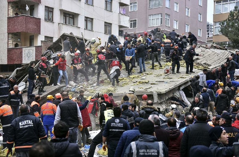 Rescue crews work to remove the debris of an eight-story building that collapsed Wednesday in Istanbul. 