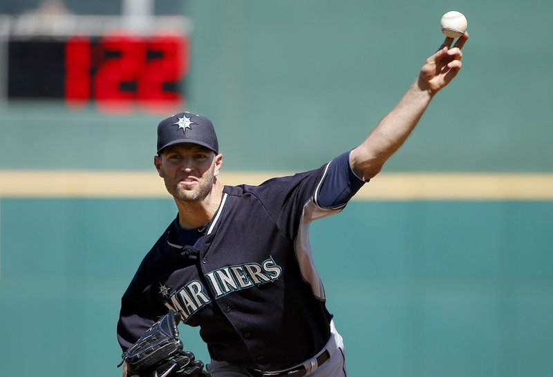 In this March 8, 2015, file photo, Seattle Mariners' J.A. Happ throws a pitch between innings as pitch clock counts down in the background during a spring training baseball game against the Cincinnati Reds in Goodyear, Ariz. Major League Baseball and its players are discussing bold changes to spark the sport that include a three-batter minimum before a pitching change except at the start of an inning, a single trade deadline set before the All-Star break and expanding rosters. (AP Photo/Ross D. Franklin, File)