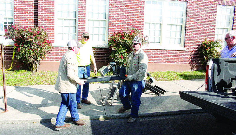 Workers from Milam Construction load the individual chimes that  make up the carillon into a vehicle. Each chime weighs about 550  pounds; in all, the instrument weighs more than 8,000 pounds. 