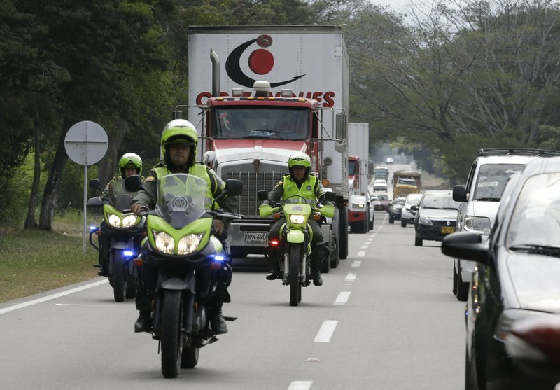 Two semi-trailer trucks containing humanitarian aid from the U.S for Venezuela are escorted by Colombian police in Los Patios, near Cucuta, Colombia, Thursday, Feb. 7, 2019, about 18 miles from the Colombian-Venezuelan border. Venezuela&#x2019;s opposition leaders requested the shipments and vowed to bring them inside the troubled nation despite objections from embattled President Nicolas Maduro. (AP Photo/Fernando Vergara)