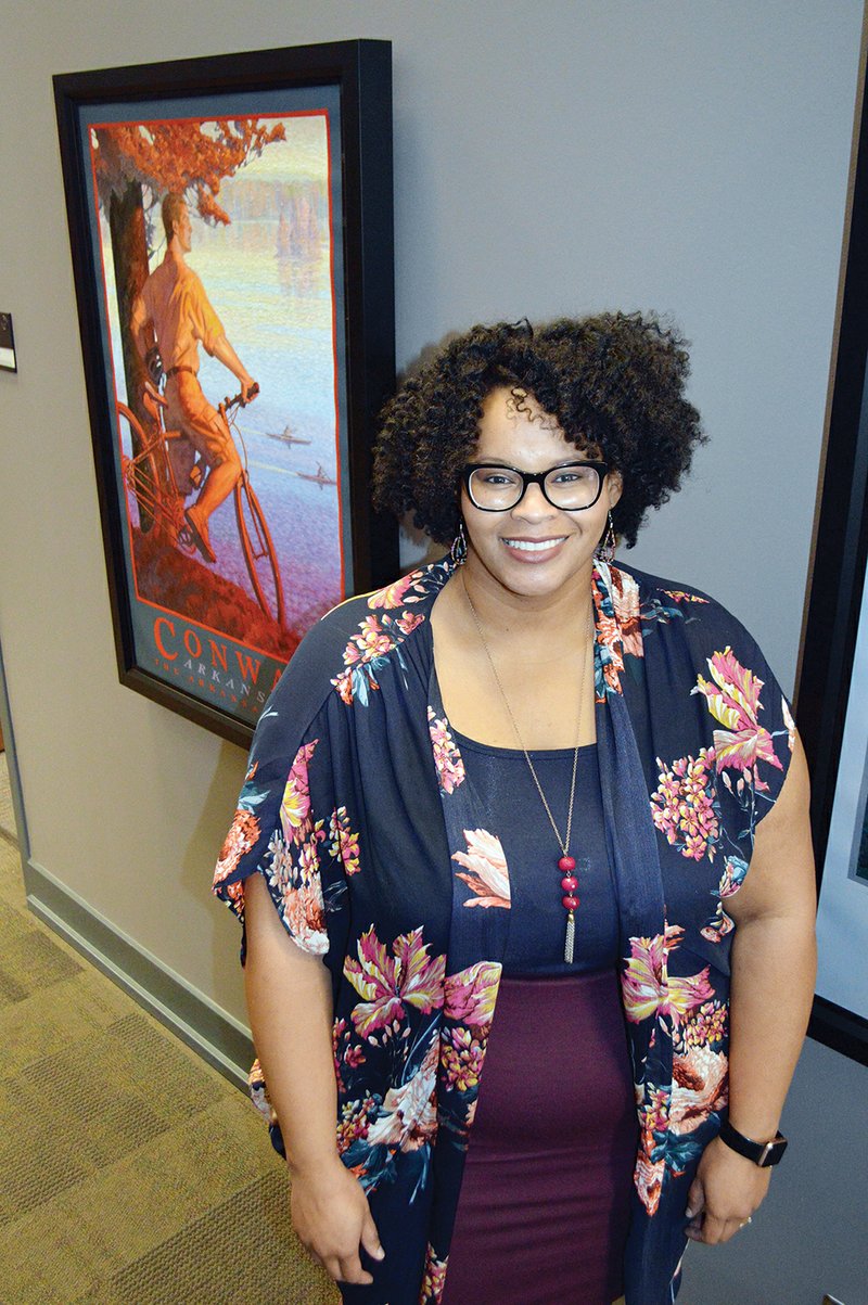 Adena White stands in the hallway of the Conway Area Chamber of Commerce. White, 34, is director of communications for the chamber. She also writes a blog, available at blackbeltvoices.com. White was inducted in January as the first black president of the Arkansas chapter of the Public Relations Society of America in its 55-year history. The woman who nominated her complimented White’s writing skills and said it was “about time” for a black president.