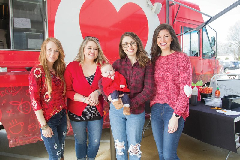 Brandi Hamilton, from left, Keli Colvin, Beth Nix, holding her daughter Eloise Nix, and Stephanie Goodwin pose for a picture during a community luncheon Feb. 1. The luncheon was in honor of National Go Red Day to help bring awareness of heart disease. Hamilton, who is the senior solutions specialist at ACDI in Benton, said her mom, Margaret Murray, died from heart failure in 2016. 