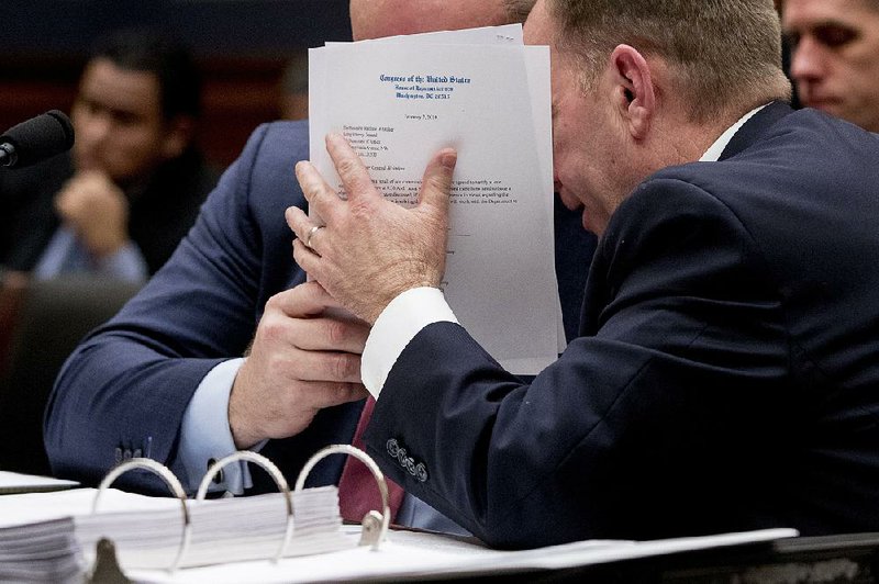 Matthew Whitaker (left) hides his face as he speaks with an aide Friday during his appearance before the House Judiciary Committee in a hearing that quickly became contentious. 