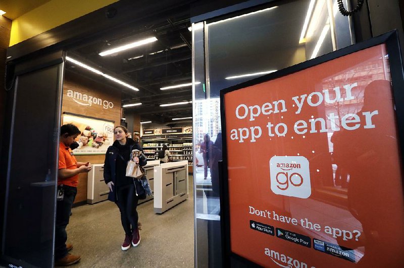 A shopper leaves an Amazon Go store in Seattle, one of 10 such stores in the U.S. with technology that automatically checks out customers who have Amazon Go apps on their smartphones so they can pick up merchandise and just walk out. 