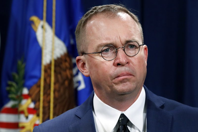 FILE- In this July 11, 2018, file photo Mick Mulvaney, acting director of the Consumer Financial Protection Bureau (CFPB), and Director of the Office of Management, listens during a news conference at the Department of Justice in Washington. White House Acting Chief of Staff Mick Mulvaney isn&#x2019;t setting any lofty goals for this weekend&#x2019;s meeting with a bipartisan mix of legislators at Camp David, but he is trying to build relationships across the aisle. (AP Photo/Jacquelyn Martin, File)